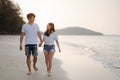 Romantic couple walking holding hands each other while at beach at sunrise. Royalty Free Stock Photo