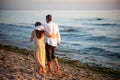 Romantic couple walking on a picturesque beach at sunset