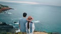 Romantic couple walking sea shore back view. Pair looking on picturesque ocean.