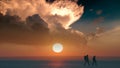 The romantic couple walking through the snow field on sunset background. Royalty Free Stock Photo