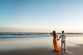 Romantic couple walking on sunset beach, enjoying evening light, relaxing on tropical summer vacation. Honeymoon. Love Royalty Free Stock Photo