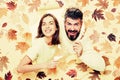 Romantic couple wearing pullover on autumn leaves background. Autumn mood and weather warm and sunny. Surprised couple