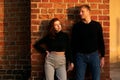 Romantic couple young beautiful sensual redhead woman and tall handsome blonde man posing in sunset sunlight on red Royalty Free Stock Photo