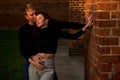 Romantic couple young beautiful sensual redhead woman and tall handsome blonde man posing in sunset sunlight on red Royalty Free Stock Photo