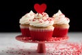 Romantic cupcakes with red heart and sprinkle decoration on frosting on cake stand