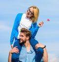 Romantic date concept. Man carries girlfriend on shoulders, sky background. Couple happy date having fun together. Woman