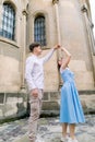 Romantic date and dance outdoor in the city. Happy young couple, man in white shirt and charming girl in blue dress Royalty Free Stock Photo