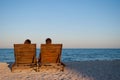 Romantic date girl and boyfriend sit on wooden deckchairs