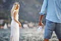 Romantic date by seaside, newlywed couple, bride in dress. Man with bottle of wine and glasses. Wedding, travel, honeymoon, love Royalty Free Stock Photo