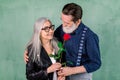 Romantic date, senior couple with a red rose in love. Senior handsome bearded man offering a rose to his partner Royalty Free Stock Photo