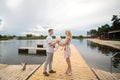 Romantic date surprise. A young guy and a girl on a pier overlooking the lake. The guy gives the girl a teddy bear