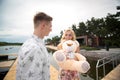 Romantic date surprise. A young guy and a girl on a pier overlooking the lake. The guy gives the girl a teddy bear