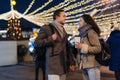 Romantic date for Valentine`s day Outdoors. Couple in love having fun on christmas decoration lights street. Young man and Woman Royalty Free Stock Photo