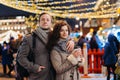 Romantic date for Valentine`s day Outdoors. Couple in love having fun on christmas decoration lights street. Young man and Woman Royalty Free Stock Photo