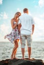 Romantic date. A young couple of Caucasian woman and man are standing on the seashore. Vertical orientation. The Royalty Free Stock Photo