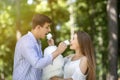 Romantic date. Young guy and girl feeding cotton candy to each other in park Royalty Free Stock Photo