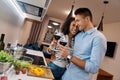 Romantic Date. Young multiethnic couple standing at kitchen cooking dinner hugging drinking wine smiling happy Royalty Free Stock Photo