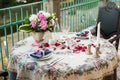 Romantic decor of the festive table in the restaurant with candles, flowers, rose petals