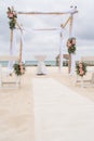 Romantic decoration of a pavilion of a beach wedding on the beach with sea in the background and cloudy sky