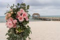 Romantic decoration with pink roses of a beach wedding on the beach with sea in the background