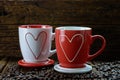 Romantic design of two coffee cups with heart shape pattern and coffee beans