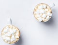 Romantic desk top with two cups of coffee with marshmallows on marble table. Top view. Royalty Free Stock Photo