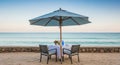 Romantic Beach Dining Setup with Umbrella and Ocean View water sand Royalty Free Stock Photo