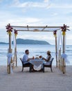 Romantic dinner on the beach in Phuket Thailand, couple man and woman mid age Asian woman and European man having a Royalty Free Stock Photo