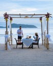 Romantic dinner on the beach in Phuket Thailand, couple man and woman mid age Asian woman and European man having a Royalty Free Stock Photo