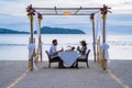 Romantic dinner on the beach in Phuket Thailand, couple man and woman mid age Asian woman and European man having a Royalty Free Stock Photo