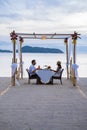 Romantic dinner on the beach in Phuket Thailand, couple man and woman mid age Asian woman and European man having a Royalty Free Stock Photo