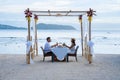 Romantic dinner on the beach in Phuket Thailand, couple man and woman mid age Asian woman and European man having a Royalty Free Stock Photo