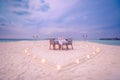 Amazing romantic dinner on the beach with candles under sunset sky. Romance and love, luxury destination dinning Royalty Free Stock Photo