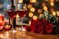 Romantic Dinner. Bouquet of flowers lying on the table, selective focus on bunch of roses, two glasses of red wine and candles on Royalty Free Stock Photo