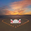 Romantic dinner with candles heart at sunset ocean beach. Proposal, wedding or honeymoon concept. Royalty Free Stock Photo