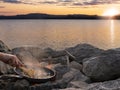 Romantic dinner prepared on the shore of the lake at sunset