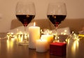 Romantic dinner scene at home: candles, box with a jewel and two glasses of wine. Royalty Free Stock Photo