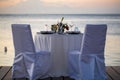 Romantic dinner setting on the beach at sunset. Royalty Free Stock Photo