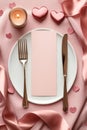 A romantic dinner setting featuring a plate, fork, knife, and neatly folded napkin, perfect for celebrating Royalty Free Stock Photo