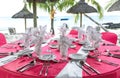 Romantic dinner on sunset beach. Pink table place setting Royalty Free Stock Photo