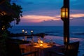 Romantic dinner table setting by the ocean at sunset with candles providing mood lighting Royalty Free Stock Photo