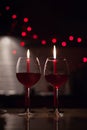 Romantic dinner: two glasses of wine and candels are in the dark with new year lights at the background Royalty Free Stock Photo