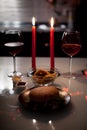 Romantic dinner two glasses of wine and candels, hamburger, nuggets are in the dark with new year lights at the background Royalty Free Stock Photo