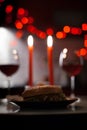 Romantic dinner two glasses of wine and candels, hamburger, nuggets are in the dark with new year lights at the Royalty Free Stock Photo