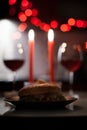 Romantic dinner two glasses of wine and candels, hamburger, nuggets are in the dark with new year lights at the Royalty Free Stock Photo