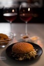 Romantic dinner: Two glasses of wine and jucy hamburger, nuggets are in the dark background with new year lights Royalty Free Stock Photo