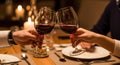 Romantic dinner with wine glasses clinking in a cozy setting Royalty Free Stock Photo