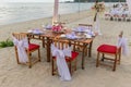 Romantic dinning table on the beach . Table setting at a luxury wedding and Beautiful flowers on the table. Royalty Free Stock Photo
