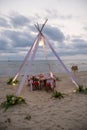 Romantic dinning table on the beach . Table setting at a luxury wedding and Beautiful flowers on the table. Royalty Free Stock Photo