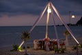 Romantic dinning table on the beach . Table setting at a luxury wedding and Beautiful flowers on the table. Royalty Free Stock Photo